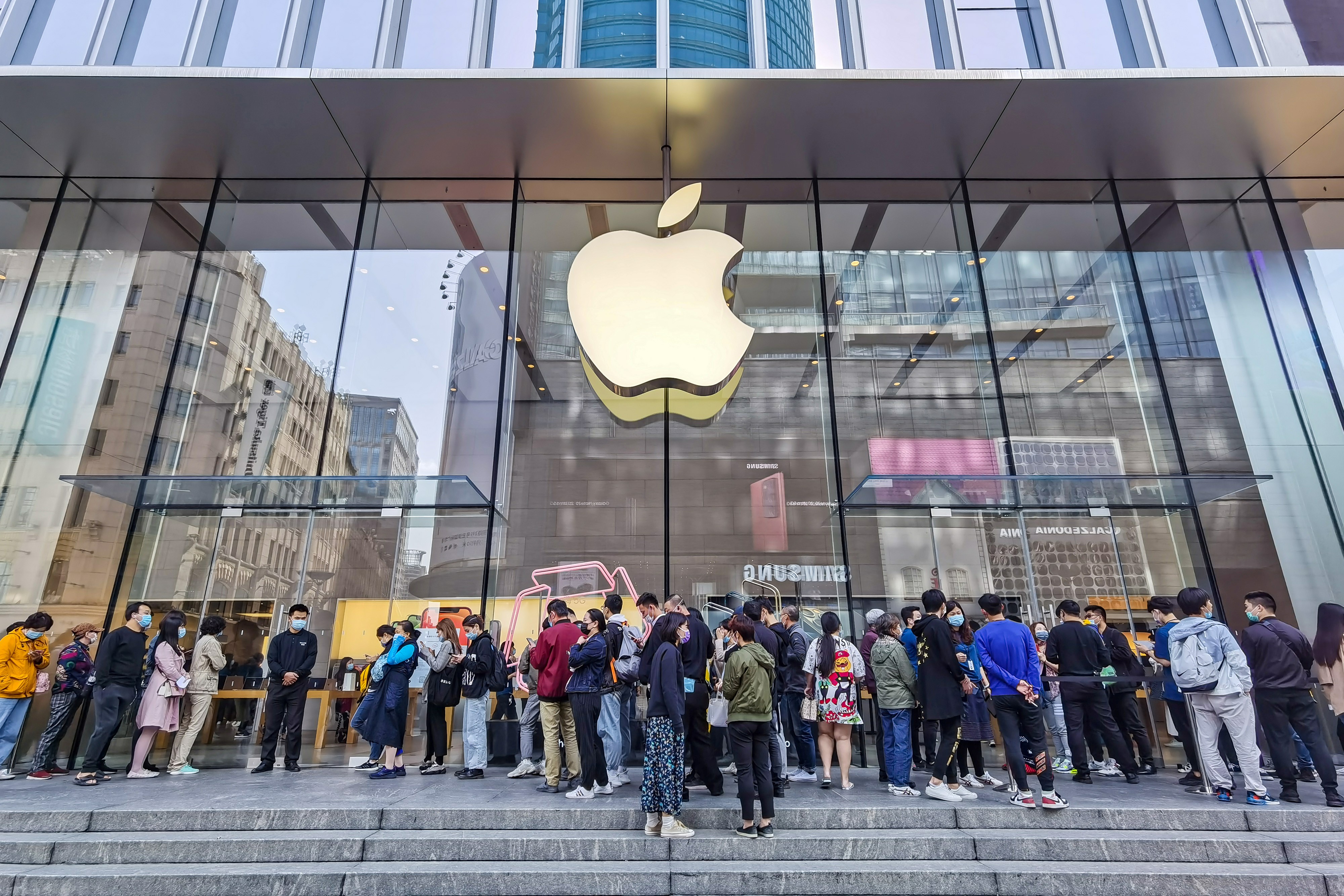 People wait outside an Apple store as the new iPhone 12 series launches in Shanghai on Oct. 23, 2020.