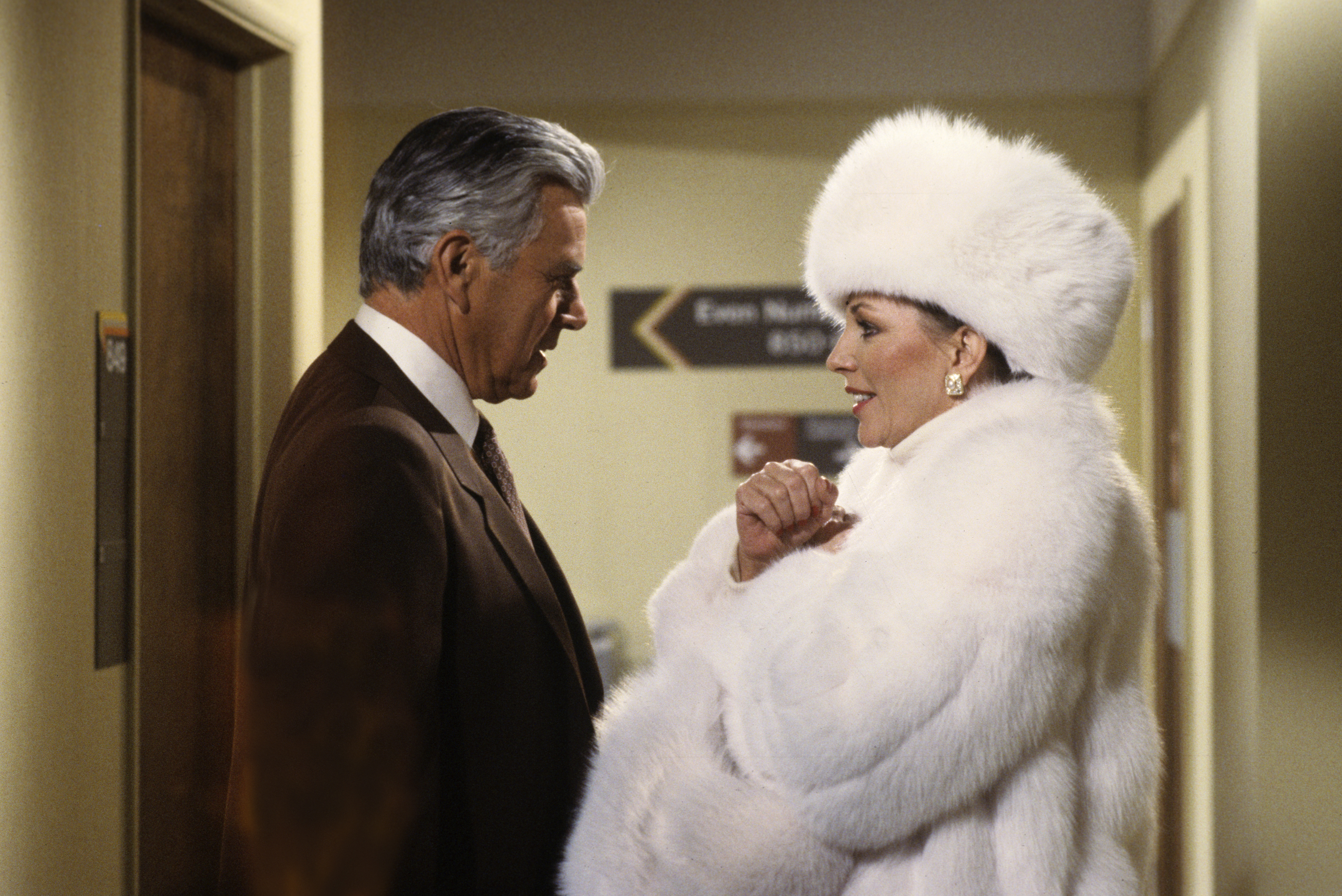 Alexis (Joan Collins) intercepted Blake (John Forsythe) at the airport to assure him that she would not be stopped from merging their respective companies on the tv show 