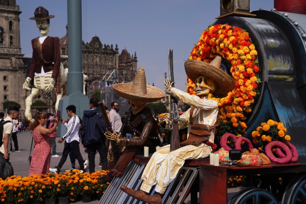 Visitors take photos of Day of the Dead themes presentations at Mexico City´s main square the Zocalo, Tuesday, Oct. 31, 2023. (AP Photo/Marco Ugarte)