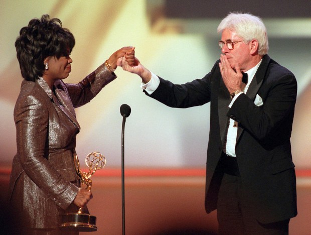 FILE - Phil Donahue blows a kiss to Oprah Winfrey as she presents him with a Lifetime Achievement Award at the 23rd Annual Daytime Emmy Awards in New York Wednesday, May 22, 1996. Donahue, whose pioneering daytime talk show launched an indelible television genre, has died. He was 88.(AP Photo/Ron Frehm, File)