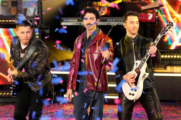 Nick Jonas, from left, Joe Jonas and Kevin Jonas from the Jonas Brothers perform during the Times Square New Year's Eve celebration on Tuesday, Dec. 31, 2024, in New York. (Photo by Charles Sykes/Invision/AP)