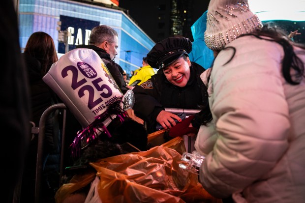 A NYPD officer talks to an elderly reveler after the ball drops in New York's Times Square, Wednesday, Jan. 1, 2025, in New York. (AP Photo/Stefan Jeremiah)