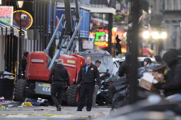 Security personnel investigate the scene on Bourbon Street after a vehicle drove into a crowd on New Orleans' Canal and Bourbon Street, Wednesday Jan. 1, 2025. (AP Photo/Gerald Herbert)