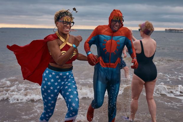 Revelers in superhero costumes walk away after entering the cold water during the annual Polar Bear Plunge on New Year's Day, Wednesday, Jan. 1, 2025, in New York. (AP Photo/Andres Kudacki)