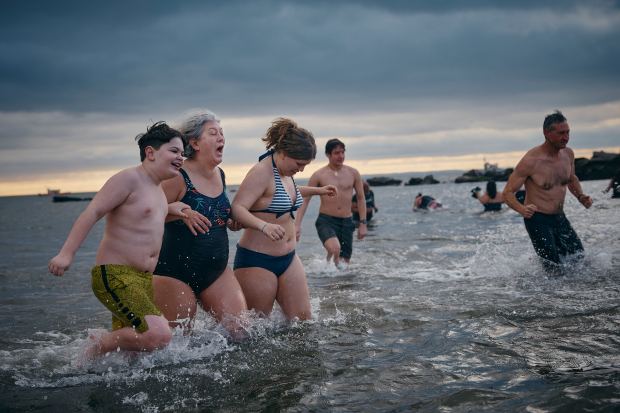 Revelers run away after entering the cold water during the annual Polar Bear Plunge on New Year's Day, Wednesday, Jan. 1, 2025, in New York. (AP Photo/Andres Kudacki)