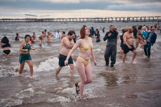 Revelers walk away after entering the cold water during the annual Polar Bear Plunge on New Year's Day, Wednesday, Jan. 1, 2025, in New York. (AP Photo/Andres Kudacki)