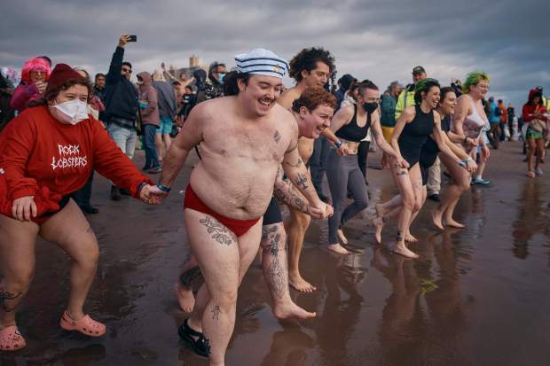 Revelers enter the cold water during the annual Polar Bear Plunge on New Year's Day, Wednesday, Jan. 1, 2025, in New York. (AP Photo/Andres Kudacki)