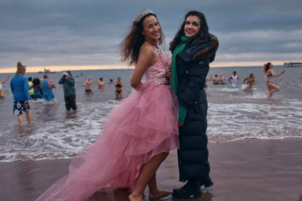 Revelers in a costume get their photo taken before the enter the cold water during the annual Polar Bear Plunge on New Year's Day, Wednesday, Jan. 1, 2025, in New York. (AP Photo/Andres Kudacki)