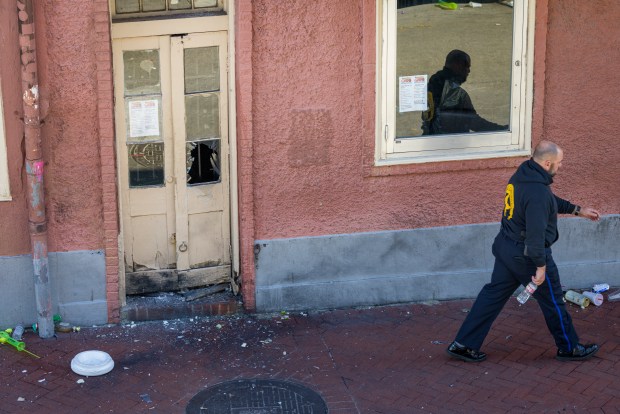 New Orleans police and federal agents walk past a doorway where an explosive device was purposely detonated by authorities as a preventative measure on Bourbon Street in New Orleans on New Year's Day on Wednesday, Jan. 1, 2025. The glass window was blown apart during the explosion. (Chris Granger/The New Orleans Advocate via AP)