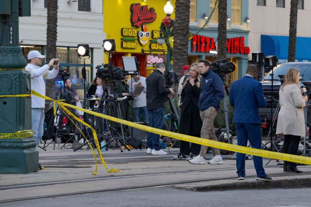 National and local media line up at the intersection of Bourbon Street and Canal Street during the investigation after a pickup truck rammed into a crowd of revelers early on New Year's Day, Wednesday, Jan. 1, 2025, in New Orleans. (AP Photo/Matthew Hinton)