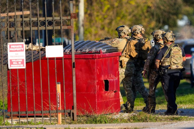 Law enforcement officers approach a location in Houston, Texas, Wednesday, Jan. 1, 2025, where police personnel investigate the place suspected to be associated with attackers in a deadly rampage in New Orleans. (Brett Coomer/Houston Chronicle via AP)