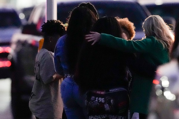 Neighbors embrace as they stand outside the police lines surrounding a location in Houston, Texas, Wednesday, Jan. 1, 2025, where police personnel investigate the place suspected to be associated with an attacker in a deadly rampage in New Orleans. (Brett Coomer/Houston Chronicle via AP)