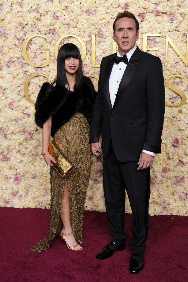 Riko Shibata, left, and Nicolas Cage arrive at the 82nd Golden Globes on Sunday, Jan. 5, 2025, at the Beverly Hilton in Beverly Hills, Calif.