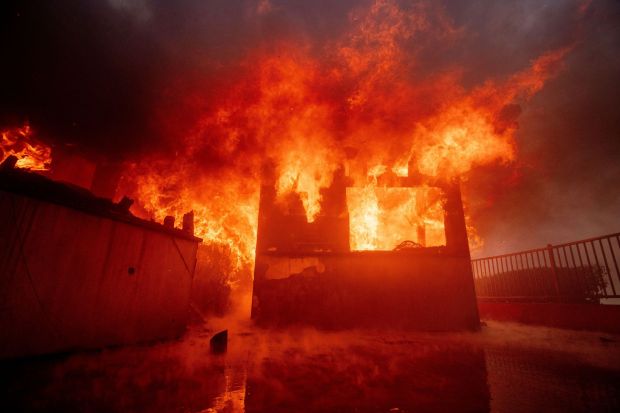 The Palisades Fire burns a property in the Pacific Palisades neighborhood of Los Angeles, Tuesday, Jan. 7, 2025. (AP Photo/Ethan Swope)