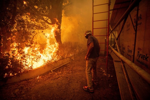 Will Adams watches as flames from the Palisades Fire close in on his property