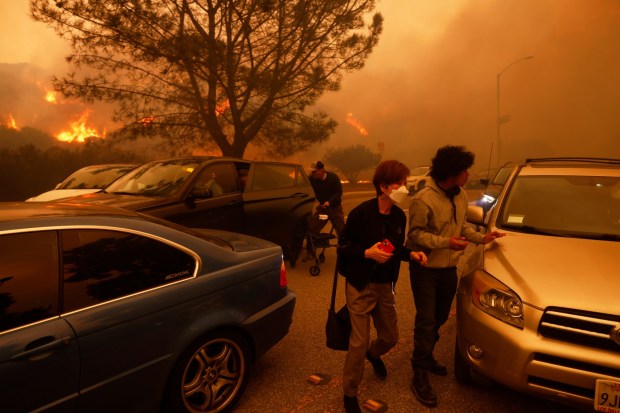 People flee from the advancing Palisades Fire, by car and on foot