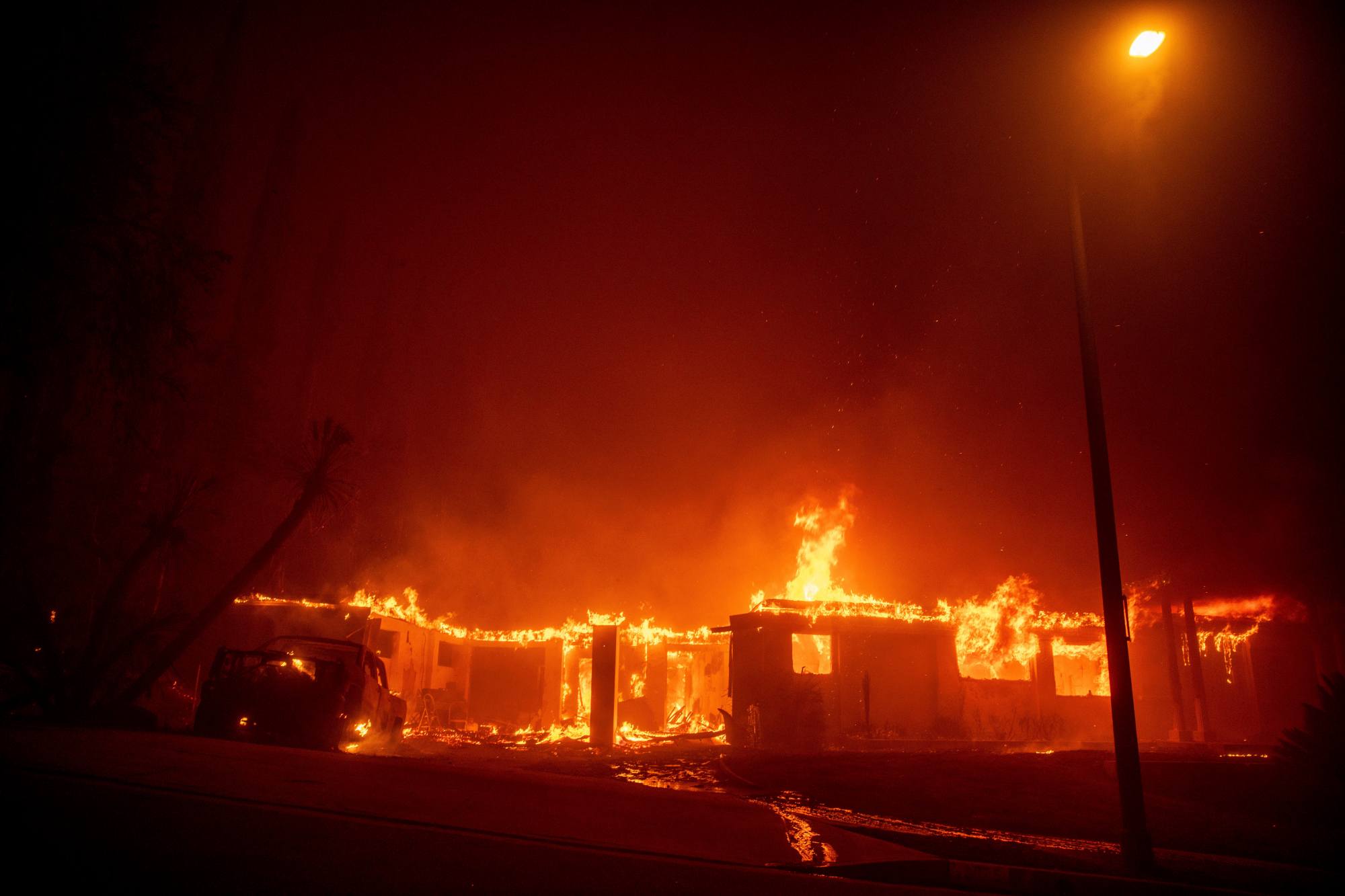 The Eaton Fire burns a structure Wednesday, Jan. 8, 2025 in Altadena, Calif. (AP Photo/Ethan Swope)