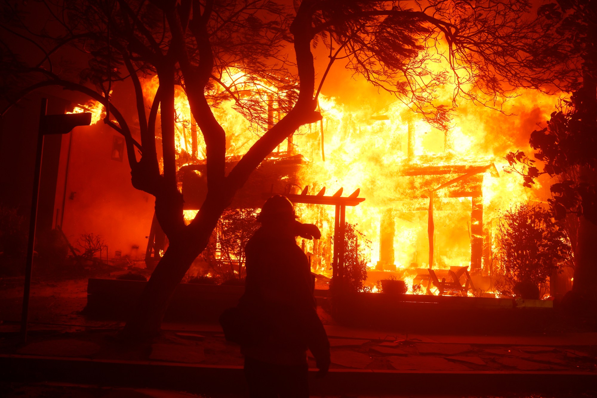 A firefighter battles the Palisades Fire in the Pacific Palisades neighborhood of Los Angeles, Tuesday, Jan. 7, 2025. (AP Photo/Etienne Laurent)