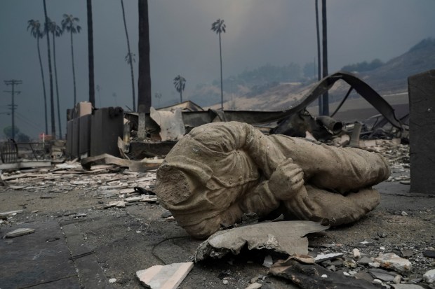 A statue and other structures are burned as the Palisades Fire ravages a neighborhood amid high winds in the Pacific Palisades neighborhood of Los Angeles, Wednesday, Jan. 8, 2025. (AP Photo/Damian Dovarganes)