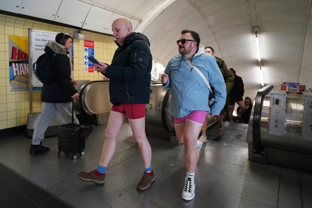 People take part in the annual event "No Trousers Tube Ride" in London, Sunday, Jan. 12, 2025. (AP Photo/Alberto Pezzali)