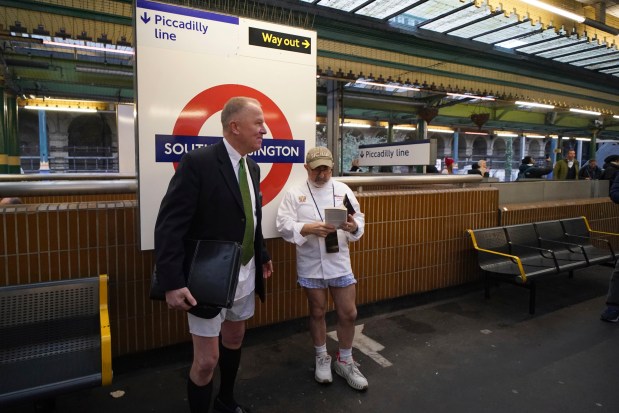 Two men wait for a tube at South Kensington station as they take part in the annual event "No Trousers Tube Ride" in London, Sunday, Jan. 12, 2025. (AP Photo/Alberto Pezzali)