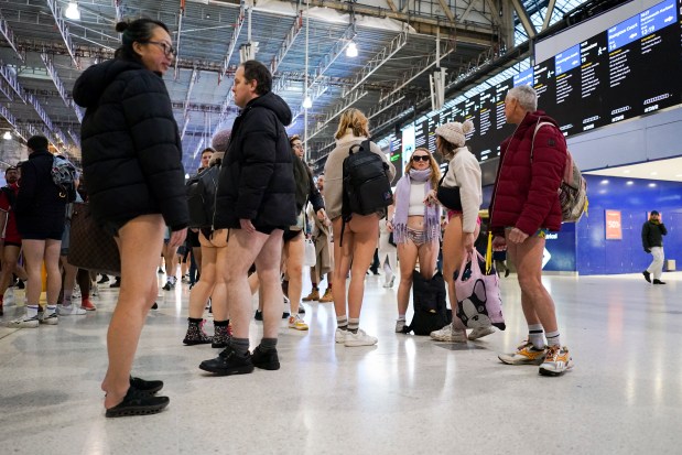 People gather at Waterloo station as they take part in the annual event "No Trousers Tube Ride" in London, Sunday, Jan. 12, 2025. (AP Photo/Alberto Pezzali)