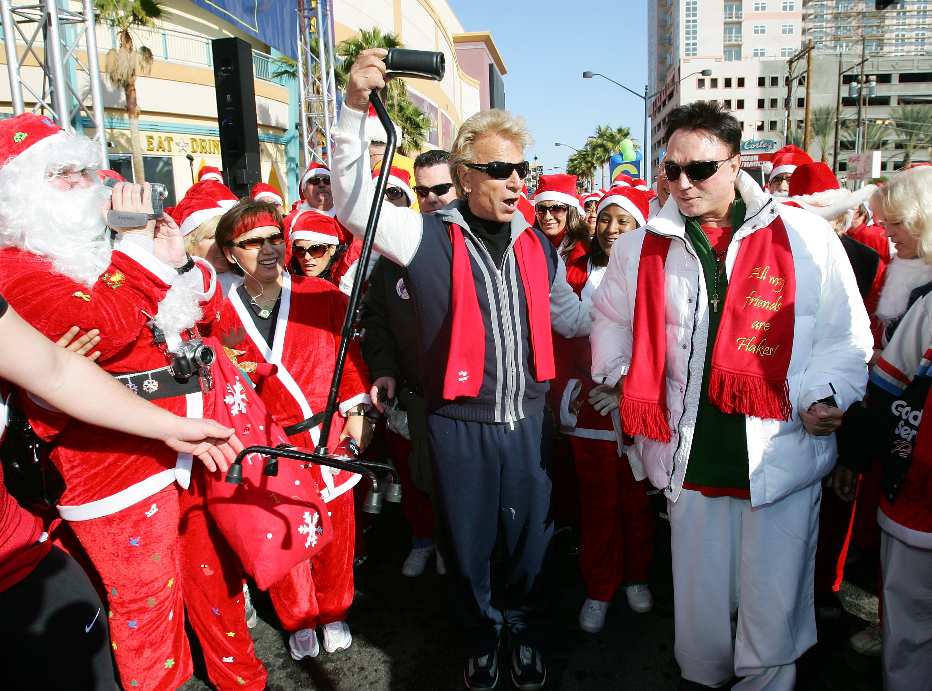 Siegfried Fischbacher, center, of the illusionist duo Siegfried & Roy, catches partner Roy Horn's cane after Horn tossed it aside at the beginning of the third annual 5K Las Vegas Great Santa Run on Dec. 1, 2007 in Las Vegas, Nevada.