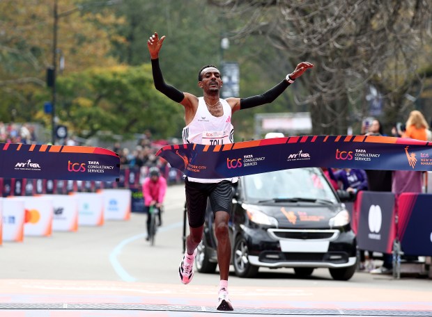 NEW YORK, NEW YORK - NOVEMBER 05: Tamirat Tola of Ethiopia celebrates as crosses the finish line giving him the win in the Men's division and setting a course record during the 2023 TCS New York City Marathon on November 05, 2023 in Central Park in New York City. (Photo by Elsa/Getty Images)