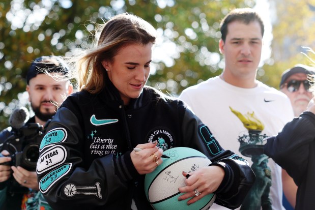 NEW YORK, NEW YORK - OCTOBER 24: Sabrina Ionescu #20 of the New York Liberty signs a basketball during the New York Liberty Ticker Tape Victory Parade & Rally on October 24, 2024 in New York City. (Photo by Sarah Stier/Getty Images)