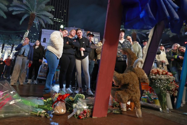 NEW ORLEANS, LOUISIANA - JANUARY 4: Friends of Bourbon Street terror attack victim Hubert Gauthreaux grieve in front of a cross dedicated him, one of fourteen crosses set up at a memorial on Canal Street near Bourbon Street on January 4, 2025 in New Orleans, Louisiana. Fourteen people were killed and over 30 were injured when a driver intentionally drove into a crowd on Bourbon Street in the early morning hours of New Year's Day in what police are calling a terrorist attack. (Photo by Michael DeMocker/Getty Images)