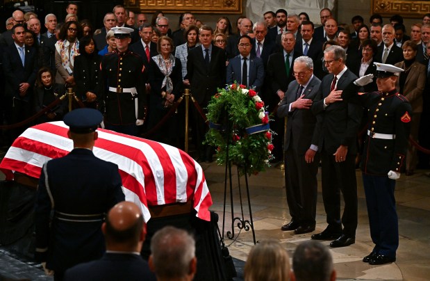 Senate Democratic leader Chuck Schumer ((L) and Senate Majority Leader John Thune (R) present a wreath during a ceremony honoring the late former US President Jimmy Carter in the Rotunda of the US Capitol, where he will lie in state, in in Washington, DC, on January 7, 2025. Carter, the 39th President of the United States, died at the age of 100 on December 29, 2024 at his home in Plains, Georgia. (Photo by Ricky Carioti / The Washington Post / AFP) (Photo by RICKY CARIOTI/The Washington Post/AFP via Getty Images)