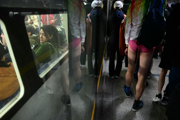 TOPSHOT - People take part in the annual "No Trousers On The Tube Day" (No Pants Subway Ride), at a station on the London Underground, in London, on January 12, 2025. This day is now marked in over 60 cities around the world. The idea behind "No Pants" is that random passengers board a subway car at separate stops in the middle of winter, without wearing trousers. (Photo by Ben STANSALL / AFP) (Photo by BEN STANSALL/AFP via Getty Images)