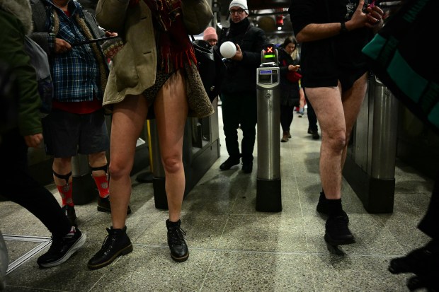 People take part in the annual "No Trousers On The Tube Day" (No Pants Subway Ride), at a station on the London Underground, in London, on January 12, 2025. This day is now marked in over 60 cities around the world. The idea behind "No Pants" is that random passengers board a subway car at separate stops in the middle of winter, without wearing trousers. (Photo by Ben STANSALL / AFP) (Photo by BEN STANSALL/AFP via Getty Images)