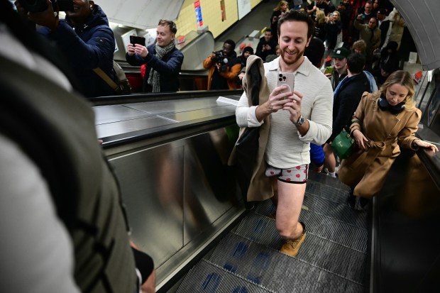 People take part in the annual "No Trousers On The Tube Day" (No Pants Subway Ride), at a station on the London Underground, in London, on January 12, 2025. This day is now marked in over 60 cities around the world. The idea behind "No Pants" is that random passengers board a subway car at separate stops in the middle of winter, without wearing trousers. (Photo by Ben STANSALL / AFP) (Photo by BEN STANSALL/AFP via Getty Images)