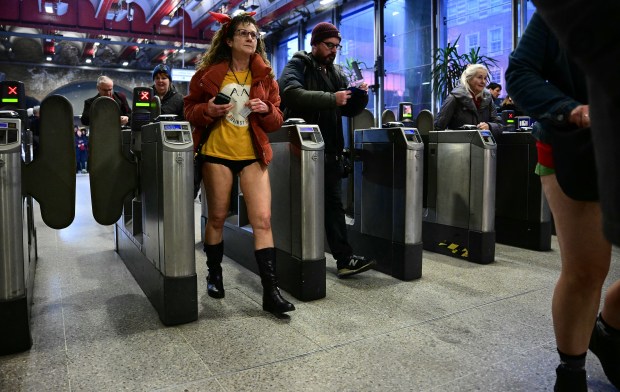 People take part in the annual "No Trousers On The Tube Day" (No Pants Subway Ride), at a station on the London Underground, in London, on January 12, 2025. This day is now marked in over 60 cities around the world. The idea behind "No Pants" is that random passengers board a subway car at separate stops in the middle of winter, without wearing trousers. (Photo by Ben STANSALL / AFP) (Photo by BEN STANSALL/AFP via Getty Images)