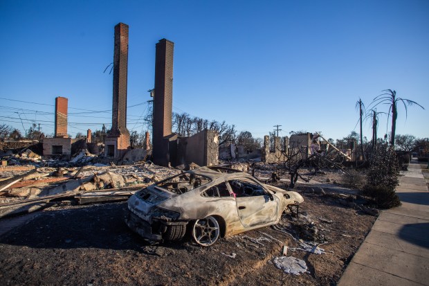 A car and homes burned by the Palisades Fire are seen on January 12, 2025 in the Pacific Palisades neighborhood of Los Angeles.