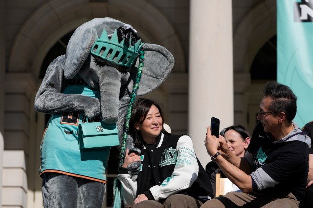 New York Liberty co-owner Joe Tsai, right, takes a picture of his wife and co-owner Clara Wu Tsai with the Liberty mascot, Ellie the Elephant, during a ceremony in honor of the New York Liberty's WNBA championship at City Hall in New York, Thursday, Oct. 24, 2024. (AP Photo/Seth Wenig)