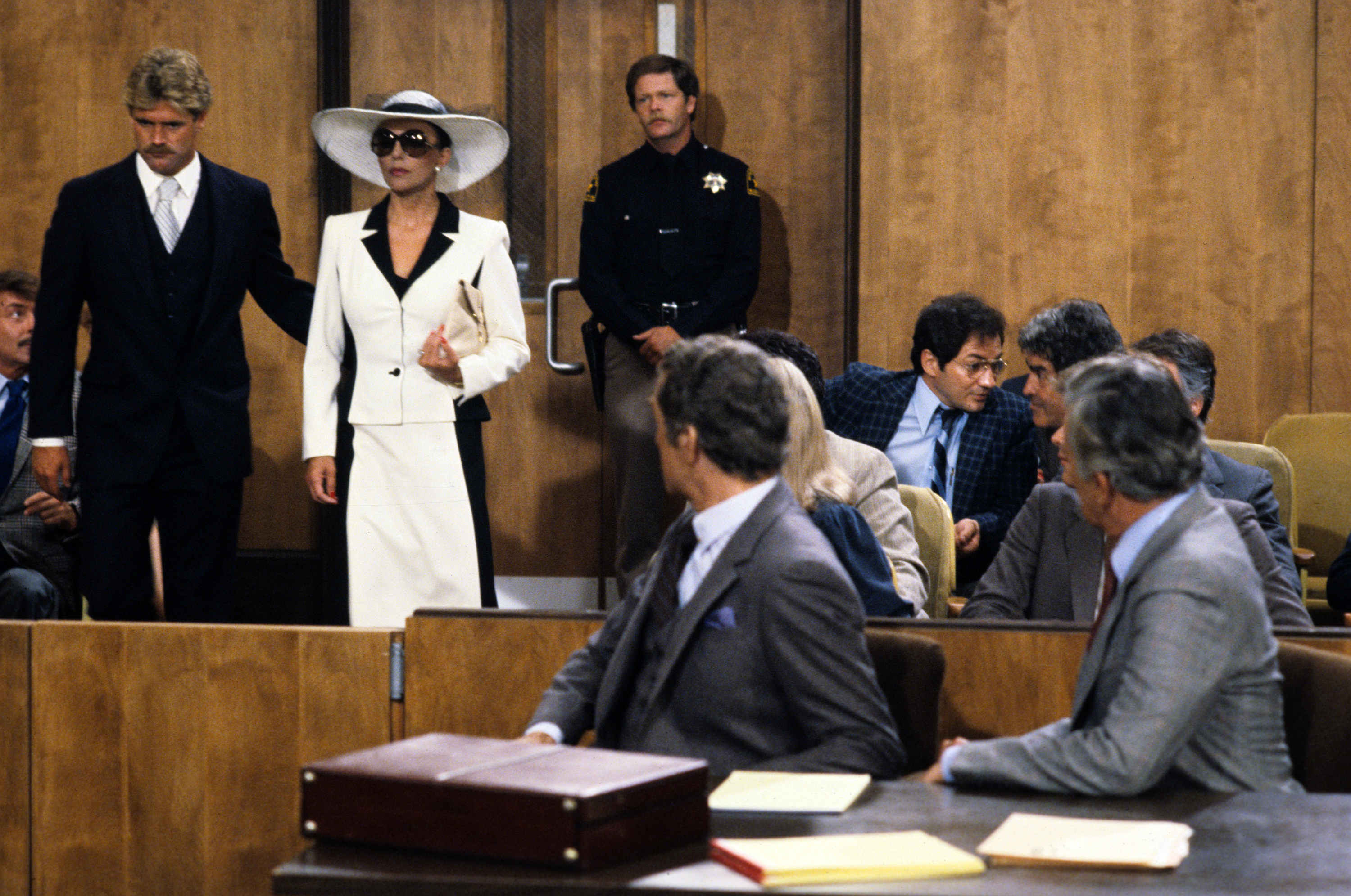 Andrew (Peter Mark Richman, center) and Blake (John Forsythe, right) watched as Jake Dunham called a new witness - Blake's first wife, Alexis (Joan Collins) - to the stand in the 'Dynasty' episode 