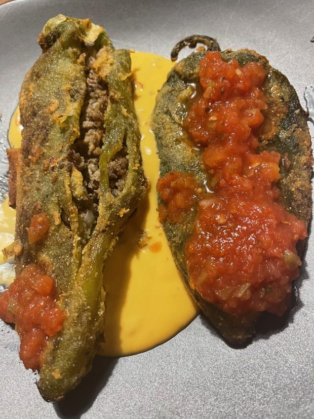 A crispy chile relleno stuffed with a ground beef mixture, bottom, goes well with a cheese-stuffed poblano relleno.(TJ Hutchinson/The Denver Post)