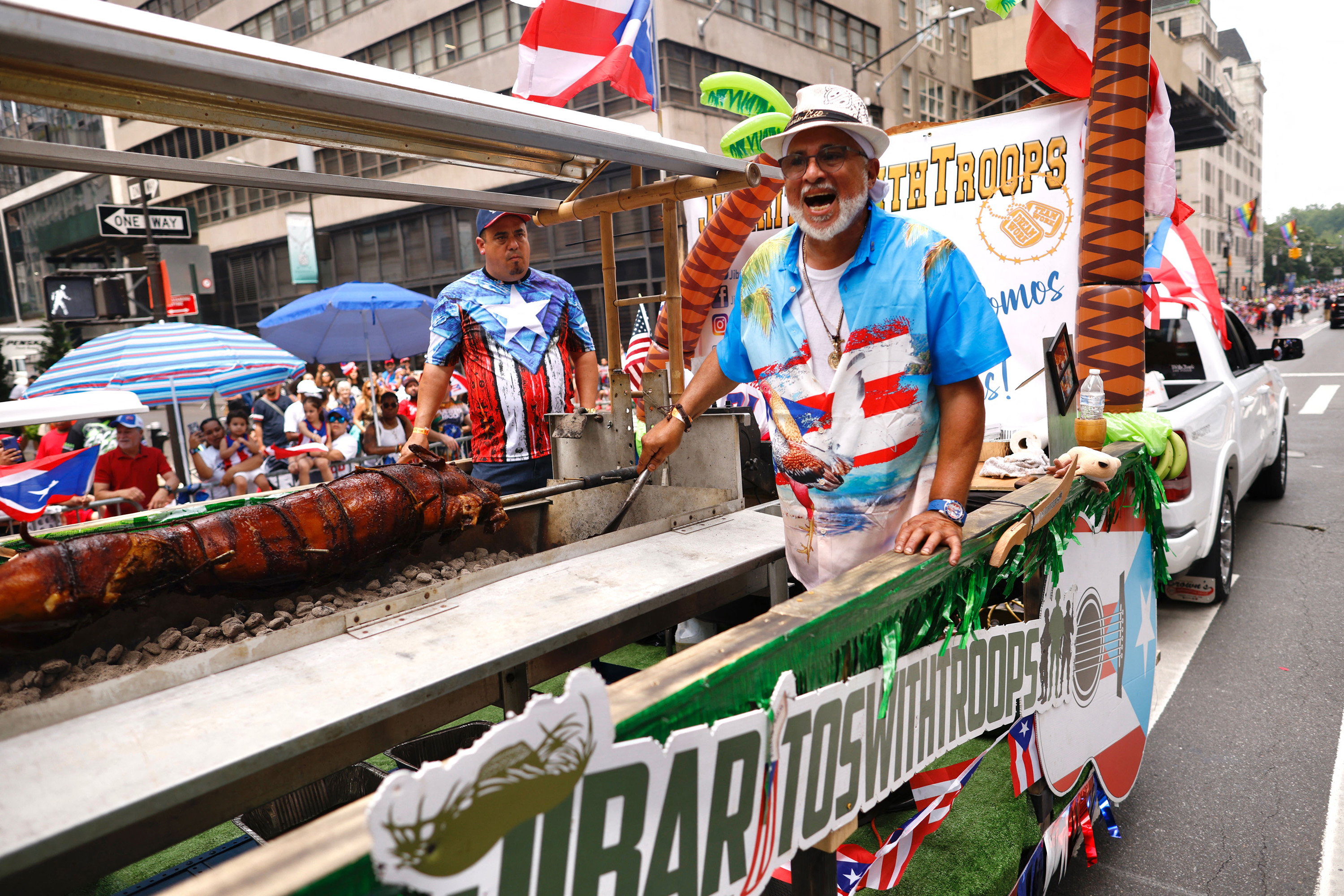 A man cooks pork inside a vehicle during the 66th annual National Puerto Rican Day Parade in New York City on June 11, 2023.