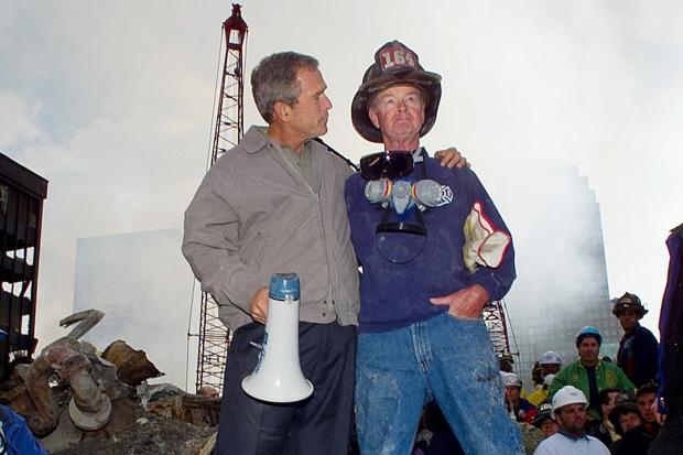 FILE As rescue efforts continue in the rubble of the World Trade Center in New York, President George W. Bush, left, stands with New York City firefighter Bob Beckwith on a burnt fire truck in front of the World Trade Center during a tour of the devastation, Sept. 13, 2001. (AP Photo/Doug Mills, File)